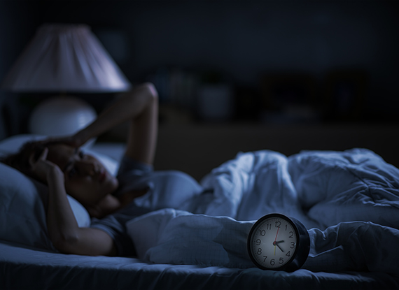 Depressed young woman lying in bed cannot sleep from insomnia